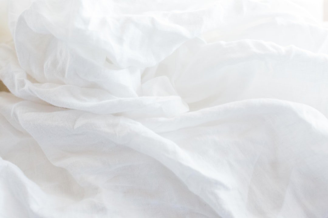 Close view of soft white bed sheets showing the fabric texture