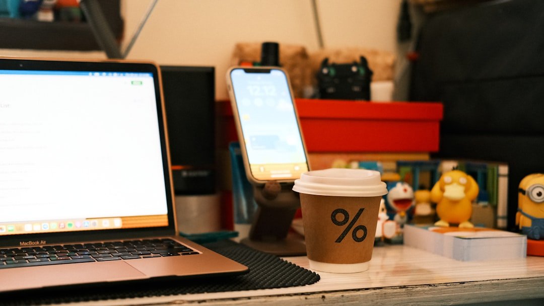a laptop computer sitting on top of a desk next to a cup of coffee