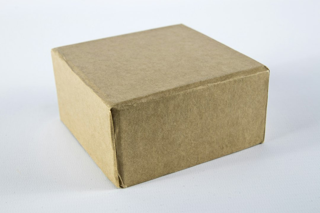 A sealed cardboard parcel on a light surface; illustrative delivery context.