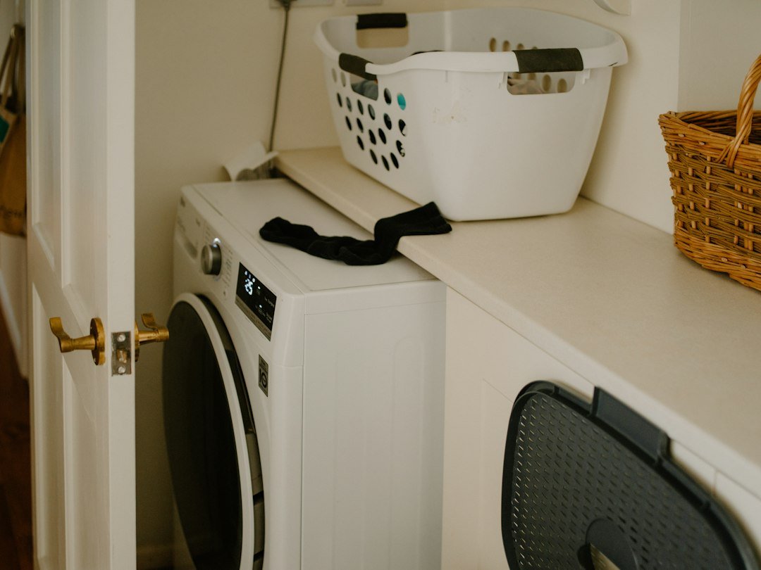 White washing machine with laundry basket and sock