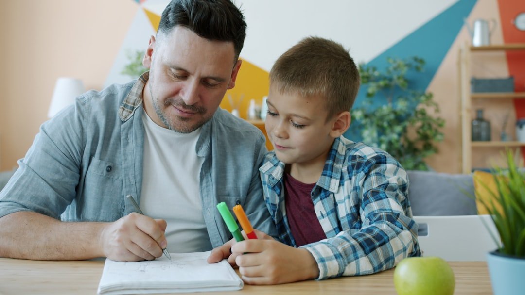 Father and son drawing together at a table
